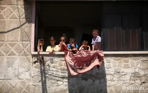 Palestinian children look out a window during a rally organized by supporters of the Islamist party Hizb Ut-Tahrir to mark the 95th anniversary of the overthrow of the Islamic Caliphate, in Gaza city on May 5, 2016. Phot...