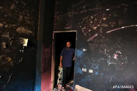 A Palestinian man looks at the charred walls of a house after a candle caused a fire at the al-Hendi family's home at the al-Shati refugee camp in Gaza City on May 7, 2016. Photo by Ashraf Amra