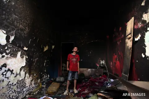 A Palestinian boy looks at the charred walls of a house after a candle caused a fire at the al-Hendi family's home at the al-Shati refugee camp in Gaza City on May 7, 2016. Photo by Ashraf Amra