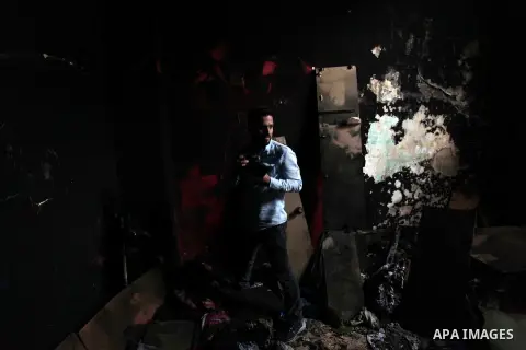 A Palestinian photographer take a photo for a torched house of al-Hendi family's after a candle caused a fire at the their house at the al-Shati refugee camp in Gaza City on May 7, 2016. Photo by Ashraf Amra