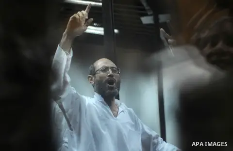 Defendants of Egyptian Muslim Brotherhood shot slogans from behind the defendant's bars during their trial at the police academy along with Egypt's ousted Islamist president Mohamed Morsi (unseen) in Cairo on May 7, 2016...