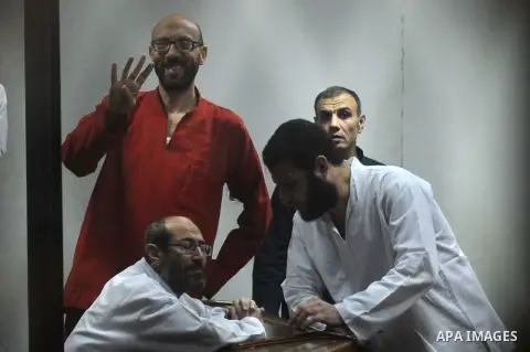 Defendants of Egyptian Muslim Brotherhood sit behind bars during their trial at the police academy along with Egypt's ousted Islamist president Mohamed Morsi (unseen) in Cairo on May 7, 2016. An Egyptian court recommende...