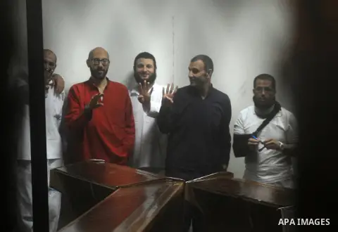 Defendants of Egyptian Muslim Brotherhood sit behind bars during their trial at the police academy along with Egypt's ousted Islamist president Mohamed Morsi (unseen) in Cairo on May 7, 2016. An Egyptian court recommende...