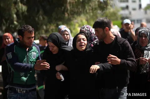 The mother of the al-Hindi family mourns during the funeral of three of her sons who died in a fire caused by a candle at the family home, at the al-Shati refugee camp in Gaza City on May 7, 2016. Photo by Ashraf Amra