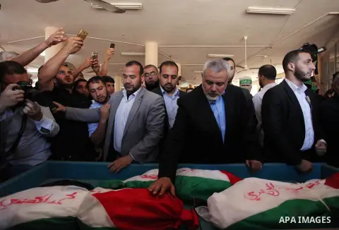 Palestinian Islamist movement Hamas' chief, Ismail Haniya mourns next to the bodies of three children from the al-Hindi family, who died in a fire caused by a candle at the family home at the al-Shati refugee camp in Gaz...