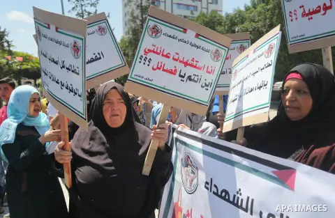 Palestinians hold placards during a protest against a power cut and the Israeli blockade of the Gaza Strip, in Gaza city on May 8, 2016. Photo by Mohammed Asad
