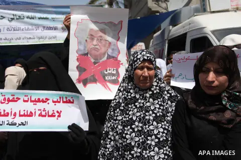 Palestinian children hold placards during a protest against the killing of three boys from the al-Hindi family, who died in a fire caused by a candle at the family home in Gaza city on May 9, 2016. Photo by Ashraf Amra