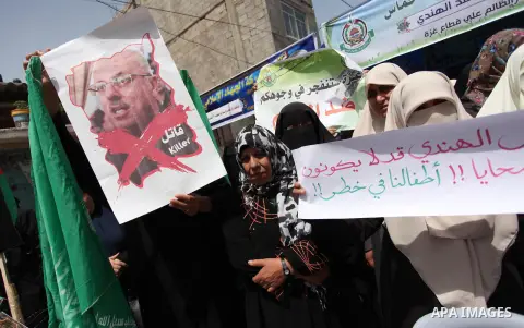 Palestinian children hold placards during a protest against the killing of three boys from the al-Hindi family, who died in a fire caused by a candle at the family home in Gaza city on May 9, 2016. Photo by Ashraf Amra