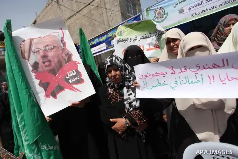 Palestinian children hold placards during a protest against the killing of three boys from the al-Hindi family, who died in a fire caused by a candle at the family home in Gaza city on May 9, 2016. Photo by Ashraf Amra