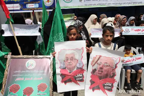 Palestinian children hold placards during a protest against the killing of three boys from the al-Hindi family, who died in a fire caused by a candle at the family home in Gaza city on May 9, 2016. Photo by Ashraf Amra