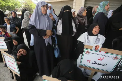 Palestinian families of martyrs, hold banners during a protest to demand their salaries, in Gaza city, on May 10, 2016. Photo by Mohammed Asad