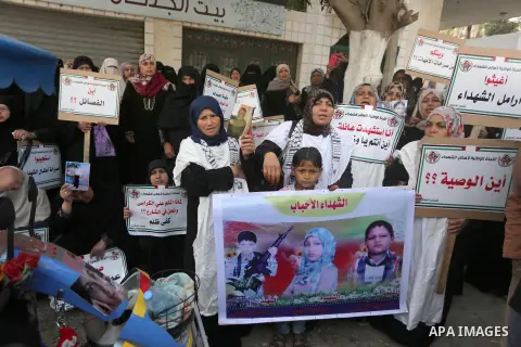 Palestinian families of martyrs, hold banners during a protest to demand their salaries, in Gaza city, on May 10, 2016. Photo by Mohammed Asad