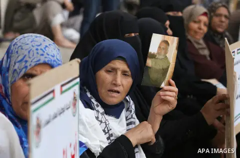 Palestinian families of martyrs, hold banners during a protest to demand their salaries, in Gaza city, on May 10, 2016. Photo by Mohammed Asad
