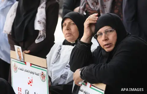 Palestinian families of martyrs, hold banners during a protest to demand their salaries, in Gaza city, on May 10, 2016. Photo by Mohammed Asad