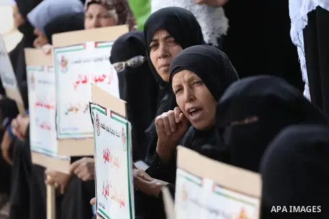 Palestinian families of martyrs, hold banners during a protest to demand their salaries, in Gaza city, on May 10, 2016. Photo by Mohammed Asad