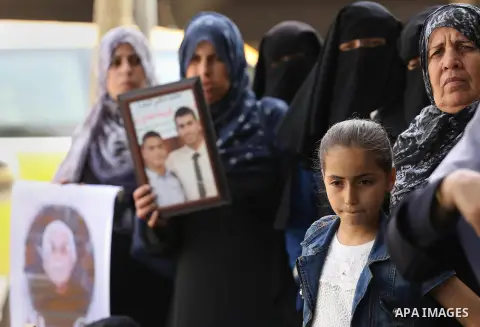 Palestinian families of martyrs, hold banners during a protest to demand their salaries, in Gaza city, on May 10, 2016. Photo by Mohammed Asad