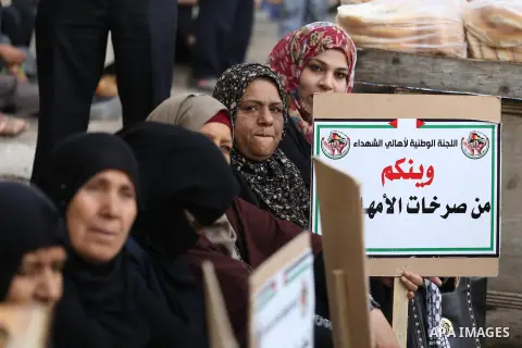 Palestinian families of martyrs, hold banners during a protest to demand their salaries, in Gaza city, on May 10, 2016. Photo by Mohammed Asad