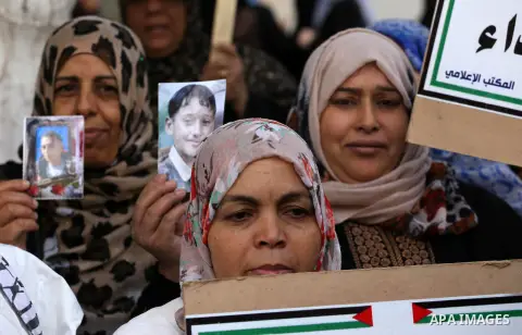 Palestinian families of martyrs, hold banners during a protest to demand their salaries, in Gaza city, on May 10, 2016. Photo by Mohammed Asad