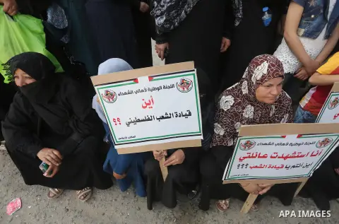 Palestinian families of martyrs, hold banners during a protest to demand their salaries, in Gaza city, on May 10, 2016. Photo by Mohammed Asad