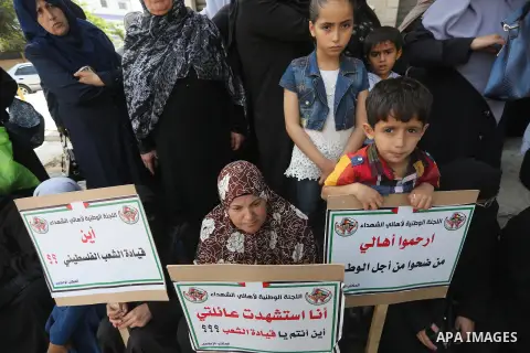 Palestinian families of martyrs, hold banners during a protest to demand their salaries, in Gaza city, on May 10, 2016. Photo by Mohammed Asad