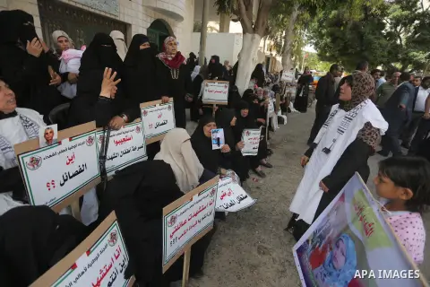 Palestinian families of martyrs, hold banners during a protest to demand their salaries, in Gaza city, on May 10, 2016. Photo by Mohammed Asad