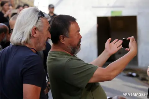 Chinese artist Ai Weiwei takes pictures with his phone as he works on a documentary film on refugees, in Nuseirat refugee camp in the central Gaza Strip on May 12, 2016. Photo by Mohammed Asad