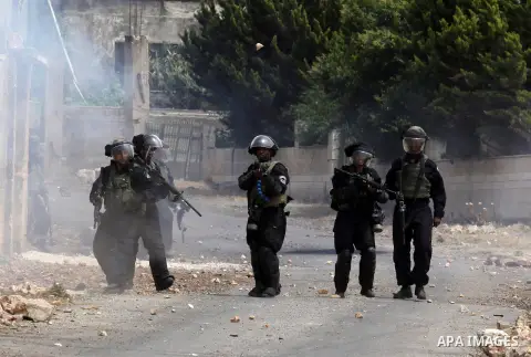 Israeli security forces aim at Palestinian protesters during clashes following a demonstration against the expropriation of Palestinian land by Israel, on May 13, 2016 in the village of Kfar Qaddum, near Nablus, in the o...