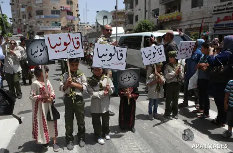 Palestinians hold a flag during in a procession on the 68th anniversary of the "Nakba" in the West Bank city of Ramallah on May 15, 2016. "Nakba" means in Arabic "catastrophe" in reference to the birth of the state of Is...