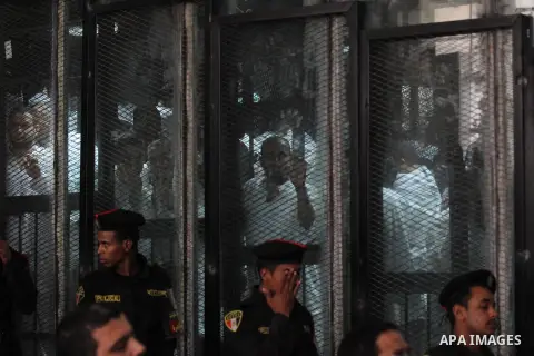 Egyptian Muslim Brotherhood members stand inside the defendants cage during their trial in the capital Cairo on May 17, 2016. Photo by Amr Sayed