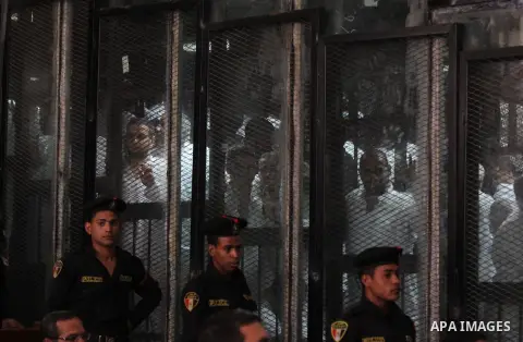 Egyptian Muslim Brotherhood members stand inside the defendants cage during their trial in the capital Cairo on May 17, 2016. Photo by Amr Sayed