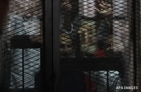 Egyptian Muslim Brotherhood members stand inside the defendants cage during their trial in the capital Cairo on May 17, 2016. Photo by Amr Sayed