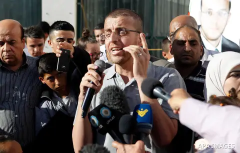 Palestinian imprisoned journalist, Mohammed al-Qiq hugs his father as he arrives in his village Dura, in southern West Bank after he was released from the Israeli Nafha Prison on May 19, 2016. Mohammed al-Qiq, 33, held b...