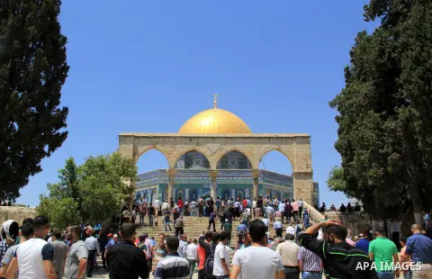 Palestinian Muslim worshipers walk in front of the Dome of the Rock mosque following Friday prayers at al-Aqsa mosque,Islam's third holiest site, in Jerusalem's Old city on May 20, 2016. Photo by Mahfouz Abu Turk