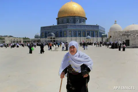 A Palestinian woman walks in front of the Dome of the Rock mosque following Friday prayers at al-Aqsa mosque,Islam's third holiest site, in Jerusalem's Old city on May 20, 2016. Photo by Mahfouz Abu Turk
