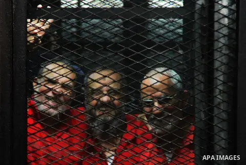 Egyptian Muslim Brotherhood members stand inside the defendants cage during their trial in the capital Cairo on May 21, 2016. Photo by Amr Sayed