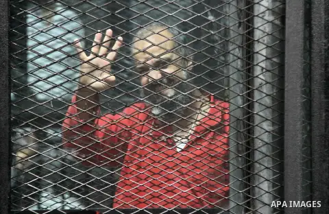 Egyptian Muslim Brotherhood members stand inside the defendants cage during their trial in the capital Cairo on May 21, 2016. Photo by Amr Sayed