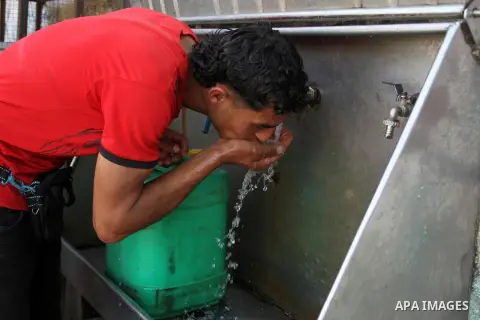 A Palestinian man drinks a water from a public tap in Rafah in the southern Gaza strip, on May 22, 2016. Photo by Abed Rahim Khatib