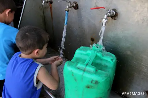 Palestinian boys drink a water from a public tap in Rafah in the southern Gaza strip, on May 22, 2016. Photo by Abed Rahim Khatib