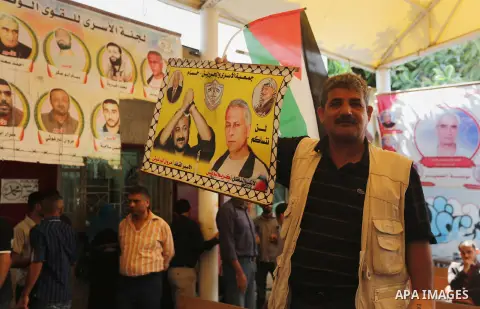Palestinians take part in a protest demanding release the prisoners in Israeli jails, in front of Red cross office, in Gaza city, on May 23, 2016. Photo by Mohammed Asad