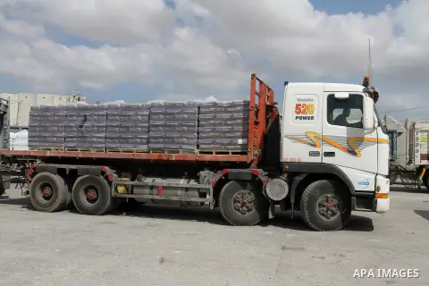 Palestinian workers stand on a truck loaded with bags of cement after it entered the southern Gaza Strip from Israel through the Kerem Shalom crossing in Rafah on May 23, 2016. Israel said on May 22 it was lifting a ban...
