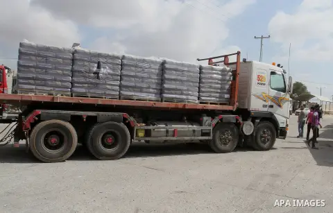 Palestinian workers stand on a truck loaded with bags of cement after it entered the southern Gaza Strip from Israel through the Kerem Shalom crossing in Rafah on May 23, 2016. Israel said on May 22 it was lifting a ban...