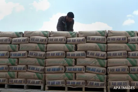 A Palestinian worker stands on a truck loaded with bags of cement after it entered the southern Gaza Strip from Israel through the Kerem Shalom crossing in Rafah on May 23, 2016. Israel said on May 22 it was lifting a ba...