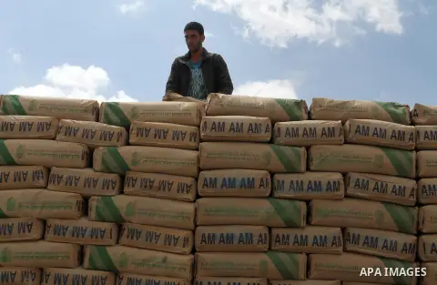 A Palestinian worker stands on a truck loaded with bags of cement after it entered the southern Gaza Strip from Israel through the Kerem Shalom crossing in Rafah on May 23, 2016. Israel said on May 22 it was lifting a ba...