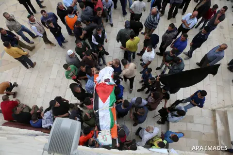 Mourners carry the body of Palestinian man Ibrahim Taha, who was shot dead by Israeli police along with his sister Maram Abu Ismail last month, during their funeral near the West Bank city of Ramallah May 23, 2016. Photo...