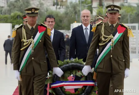 Palestinian Prime Minister Rami Hamdallah arrives with French Prime Minister Manuel Valls to lay a wreath at the tomb of the late Palestinian leader Yasser Arafat at the Muqataa, the Palestinian Authority headquarters, i...