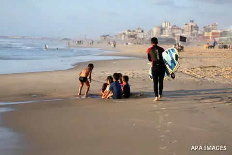 Palestinian youths enjoy a day at the beach of the Mediterranean sea on the coast of Gaza city during sunset, on May 24, 2016. Photo by Mohammed Asad