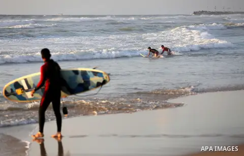 Palestinian youths enjoy a day at the beach of the Mediterranean sea on the coast of Gaza city during sunset, on May 24, 2016. Photo by Mohammed Asad