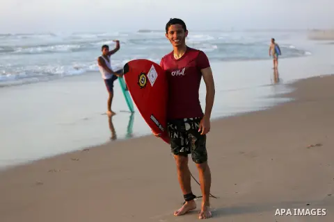 Palestinian youths enjoy a day at the beach of the Mediterranean sea on the coast of Gaza city during sunset, on May 24, 2016. Photo by Mohammed Asad