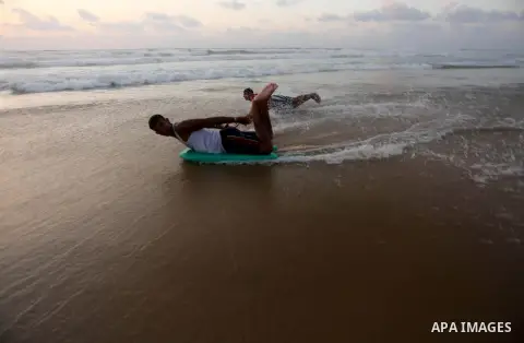 Palestinian youths enjoy a day at the beach of the Mediterranean sea on the coast of Gaza city during sunset, on May 24, 2016. Photo by Mohammed Asad