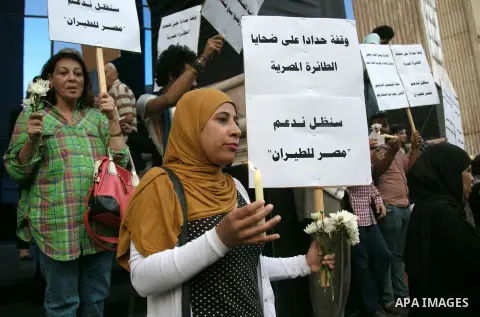 Egyptian journalists hold candles and placards supporting EgyptAir during a candlelight vigil for the victims of EgyptAir flight 804 in front of the Journalists' Syndicate in Cairo, Egypt, on May 24, 2016. The cause of T...